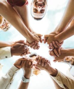 Group of diverse individuals with hands in a circle, symbolizing community and collaboration at Chicago Theological Seminary.